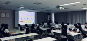 社会医療法人北斗様の受付スタッフが、講師の話を熱心に聴講している研修風景。患者様に安心感と信頼感を届ける接遇スキルを学んでいる様子。