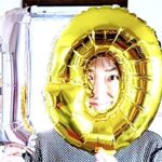 起業10周年を迎え、10周年バルーンを持って笑顔でポーズする個人事業主。全国の医療機関・官公庁・企業向け研修やメンタルヘルス支援への感謝と決意を表した記念写真。