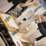 ペーパータワーワークに取り組みながら、参加者同士で協力してチームビルディングを体験する調剤薬局合同研修の様子